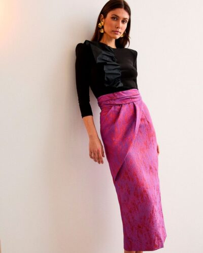 Falda midi de brocado morado-rojizo, cruzada y con cintura alta. Un diseño con personalidad para ocasiones especiales.