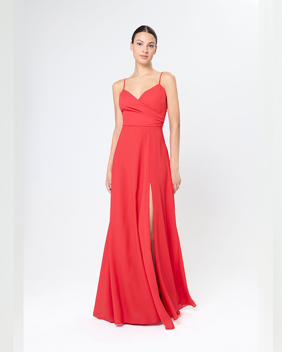 Vestido largo rojo con tirantes finos, escote cruzado y abertura frontal. Fluido y elegante.