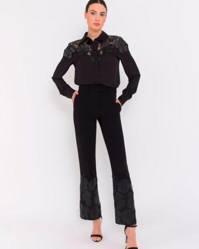 Conjunto negro sofisticado con bordados florales en polipiel en hombros y bajo del pantalón. Diseño elegante y femenino, ideal para eventos o cenas especiales.